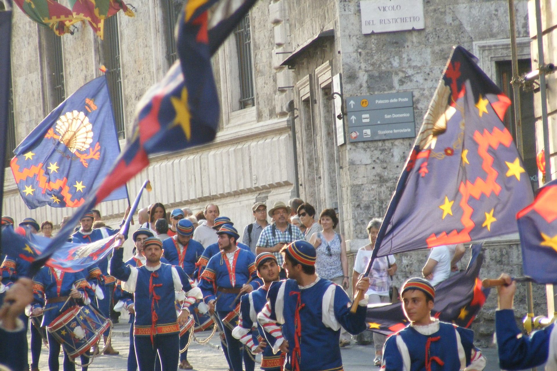 L'arrivo degli ospiti nel palazzo, con la città vestita dei colori delle contrade