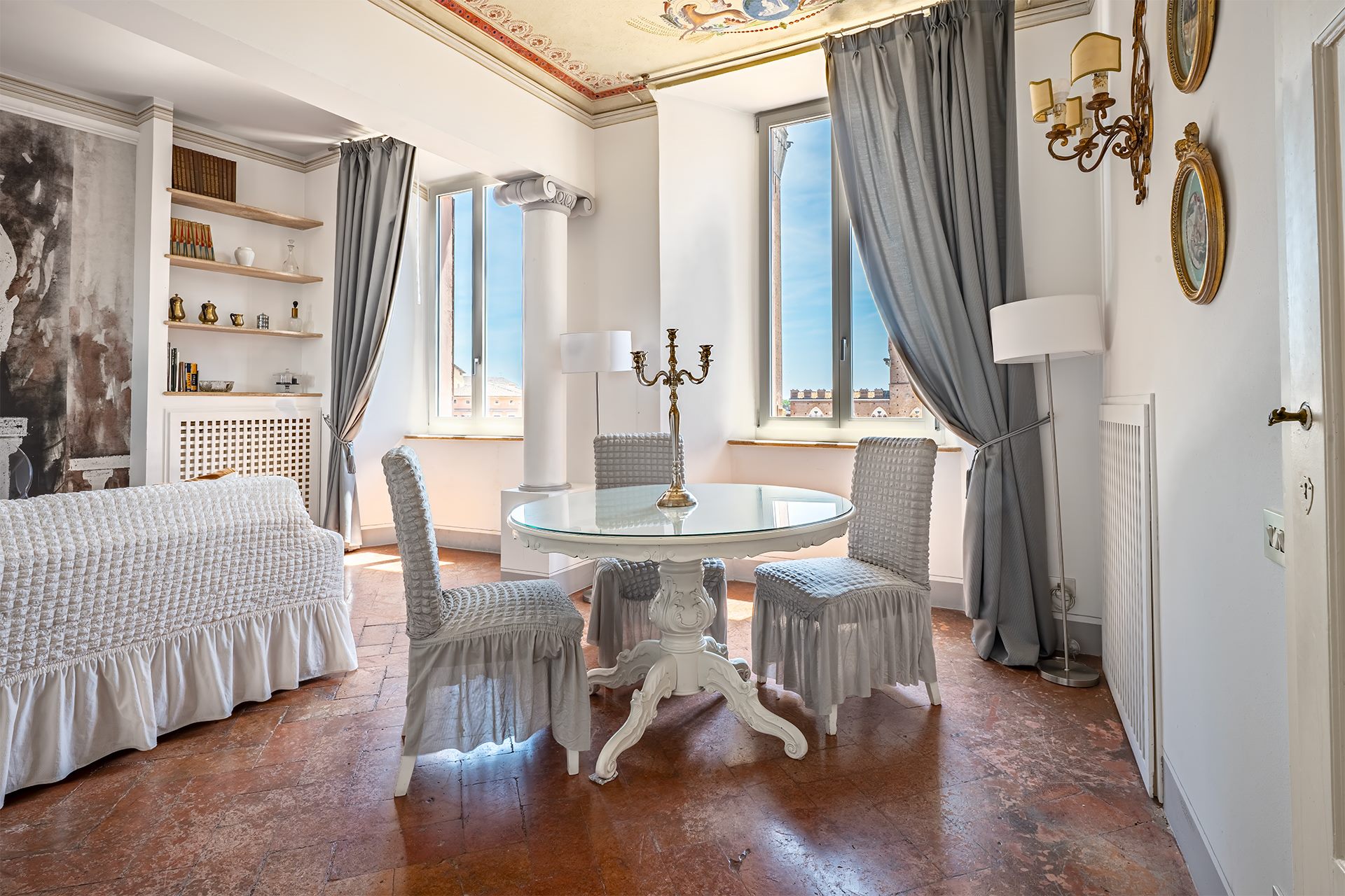 Salotto con due finestre affacciate sul Palazzo Pubblico di Siena